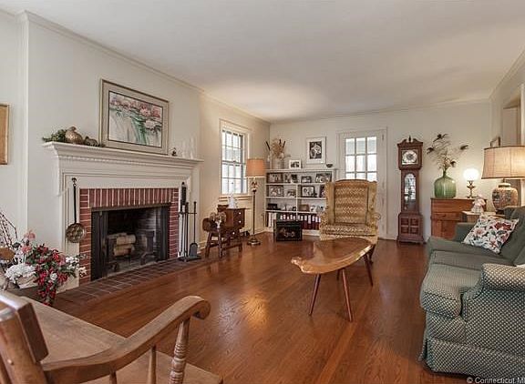 Living room with fireplace leads to enclosed porch.