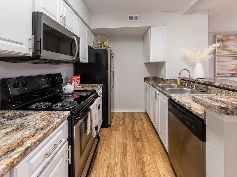 This galley-style kitchen offers stainless steel appliances, generous countertop space, and modern finishesperfect for meal prep or entertaining guests.