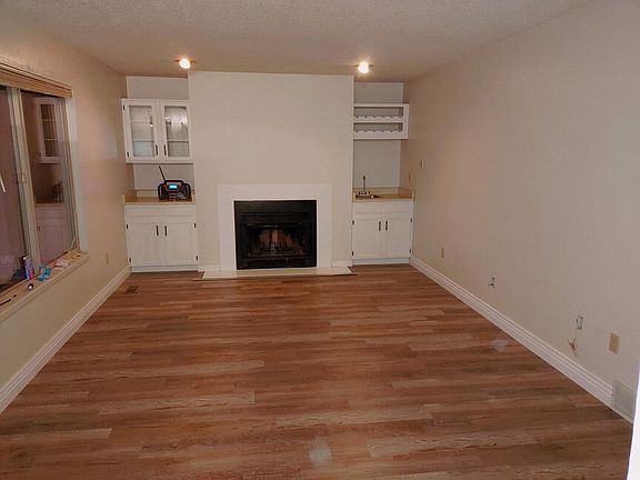 Beautiful newly painted family room with freshly painted fireplace tile, cabinets, brand new upgraded baseboards, wet bar and newly painted bright cabinets.