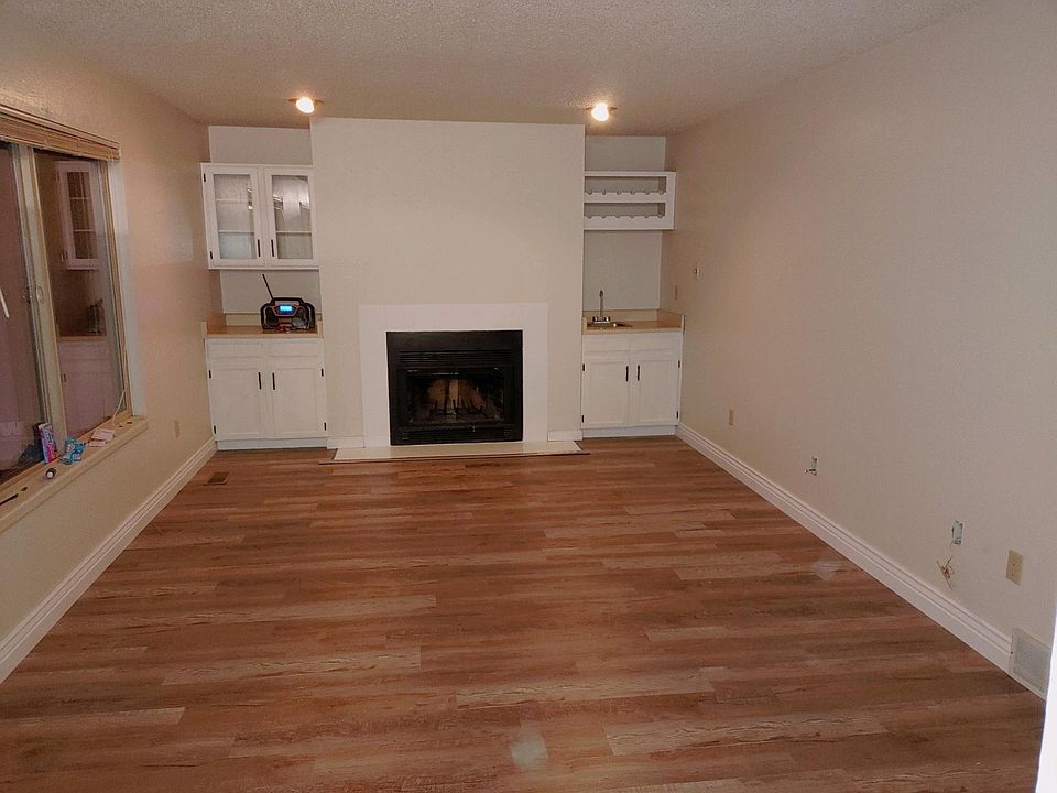 Beautiful newly painted family room with freshly painted fireplace tile, cabinets, brand new upgraded baseboards, wet bar and newly painted bright cabinets.