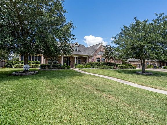 Lush landscaping and mature trees offer such great curb appeal! A long winding sidewalk leads up to this charming home with classic dormers and arched column walkways!