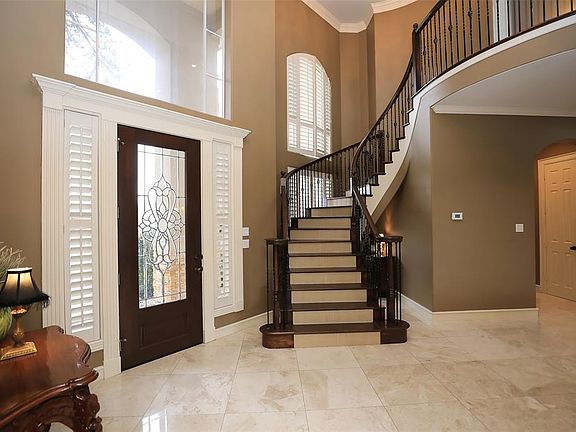 LEAD GLASS FRONT DOOR & SIDE PANELS BRIGHTEN THE ENTRY - The entry door and windows allow much natural light. Custom Plantation shutters cover the windows throughout most of the house. Notice the stunning Marble flooring as you will see throughout th