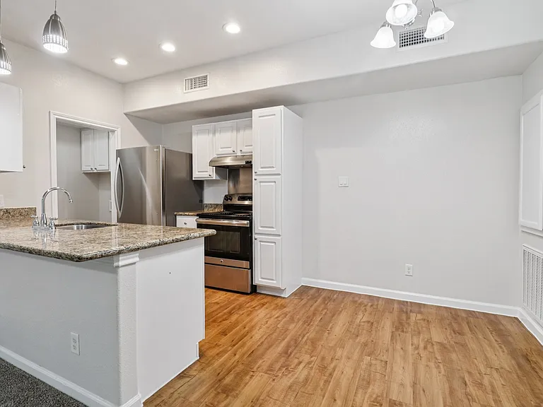 Modern kitchen with modern appliances, sleek countertops, and elegant pendant lighting. Modern kitchen with modern appliances, sleek countertops, and elegant pendant lighting.