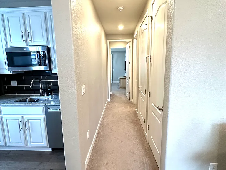 The hallway provides easy access to the bathroom, bedroom, and separate laundry room, offering a convenient and well-organized living space.