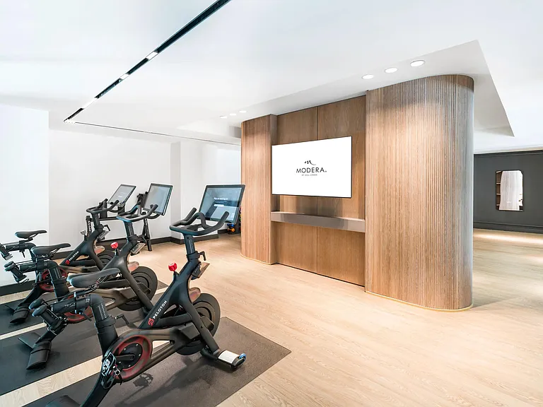 Peloton studio with connected bikes and wood-accented finishes, offering a sleek, energizing space for your daily ride.