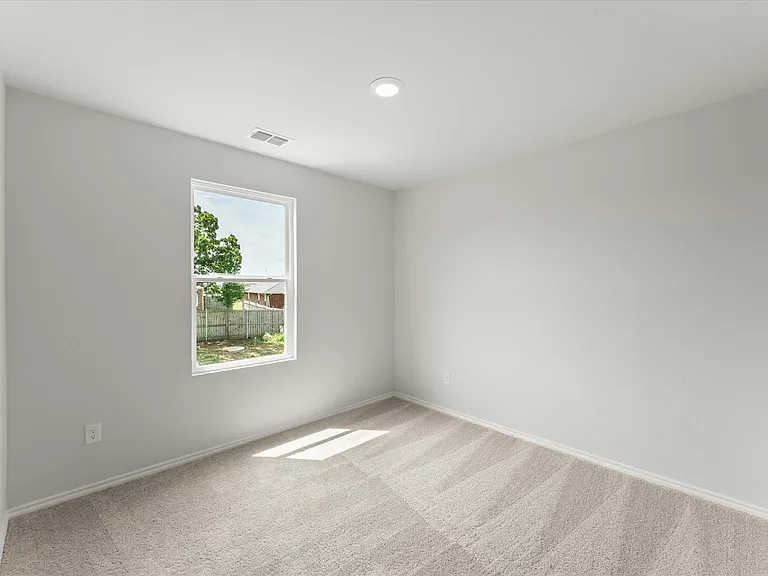 Light-filled bedroom featuring neutral wall paint, recessed ceiling lighting, a single window, and textured carpet flooring