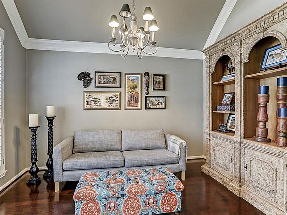 Another view of the study with hardwood floors, plantation shutters, crown molding, and updated light fixture.