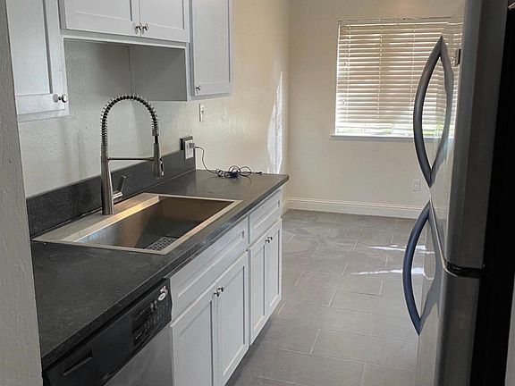 Galley kitchen has a dining area, customer cabinets, stainless appliances, dishwasher and garbage disposal. Fridge included