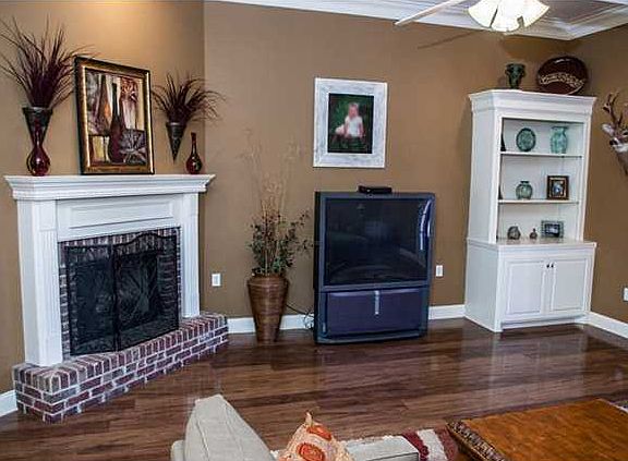 Living room upon entry is warm and inviting with neutral colors and wood flooring.