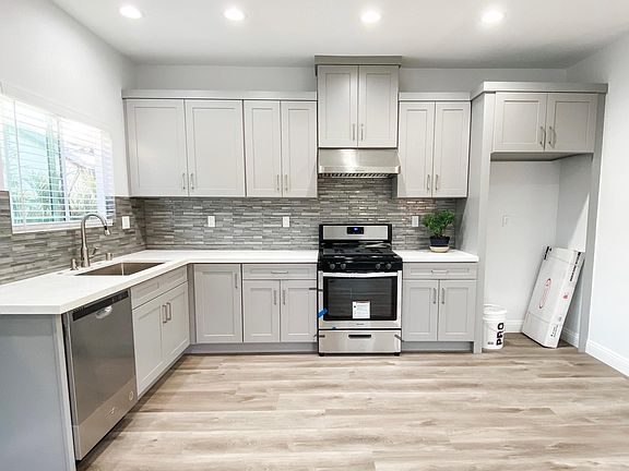 Open kitchen with brand new shaker cabinets, stainless appliances and large sink