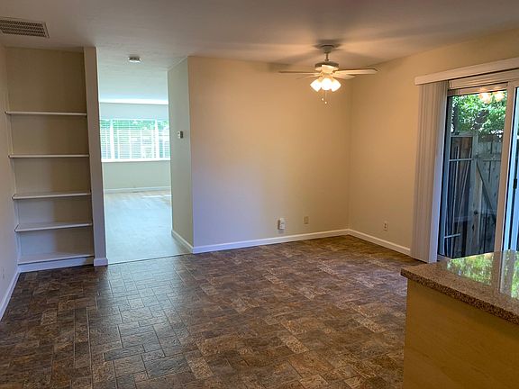View of eat-in kitchen, built in bookshelves and living room.