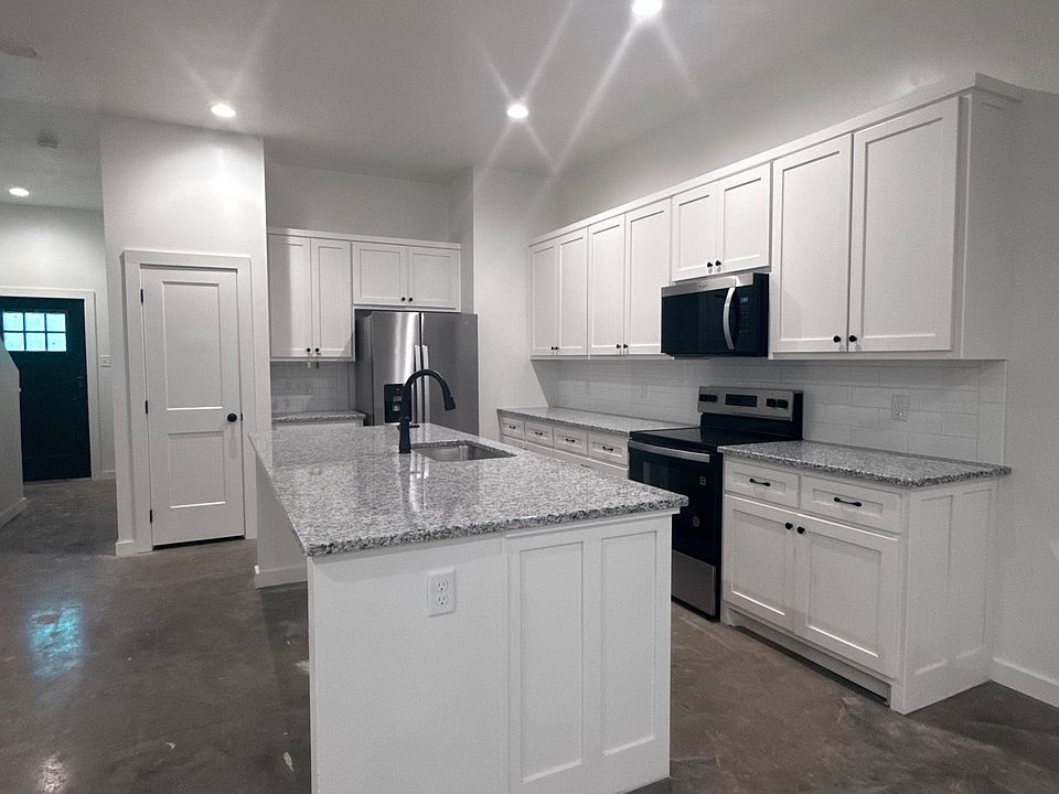 Large kitchen with eat-in island, tile backsplash, and pantry. All appliances provided, including refrigerator, microwave, dishwasher, range/oven, and disposals!