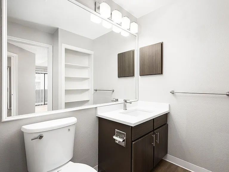 Contemporary bathroom featuring a sleek vanity with ample mirror space, elegant fixtures, and modern lighting.