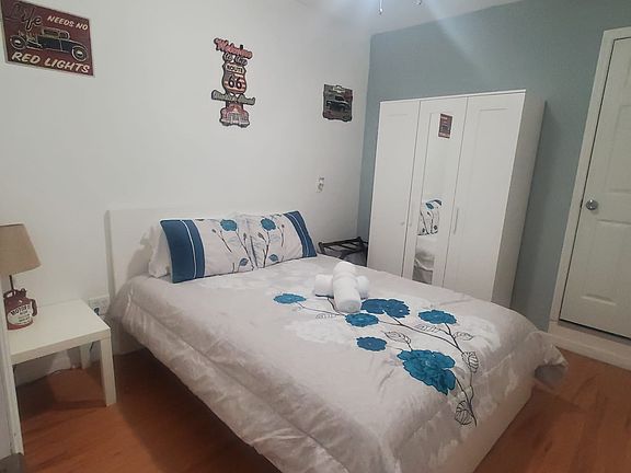 The room also includes a nightstand, lamp, and a large closet.