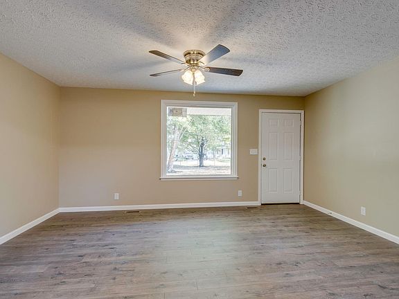 Living room is open to kitchen with new laminate flooring and fresh paint.