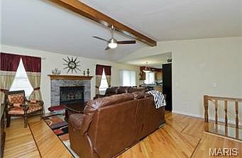 Central beam ceiling with lighted fan and wood burning fireplace