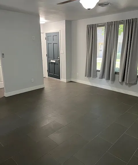 Living Room: Front Door Entry Way, New Curtains, Tile and Grout Flooring, Freshly Painted Ceiling, Walls, Baseboards, Doors and Moldings, Ceiling Fan with Light.