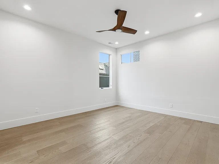 Spacious bedroom with modern finishes, recessed lighting, and ample natural light.
