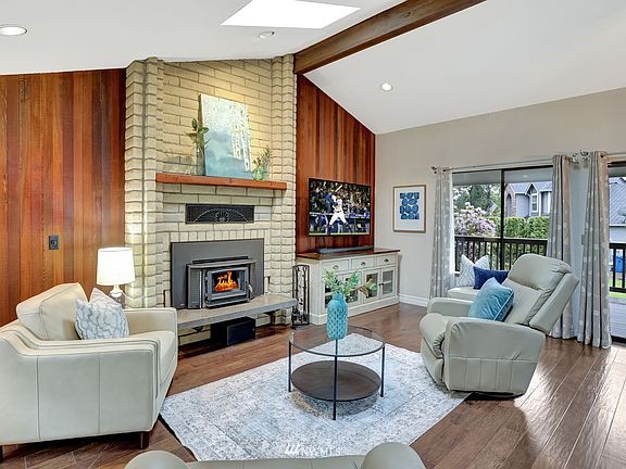 Living room with hardwood flooring, toasty wood burning stove.