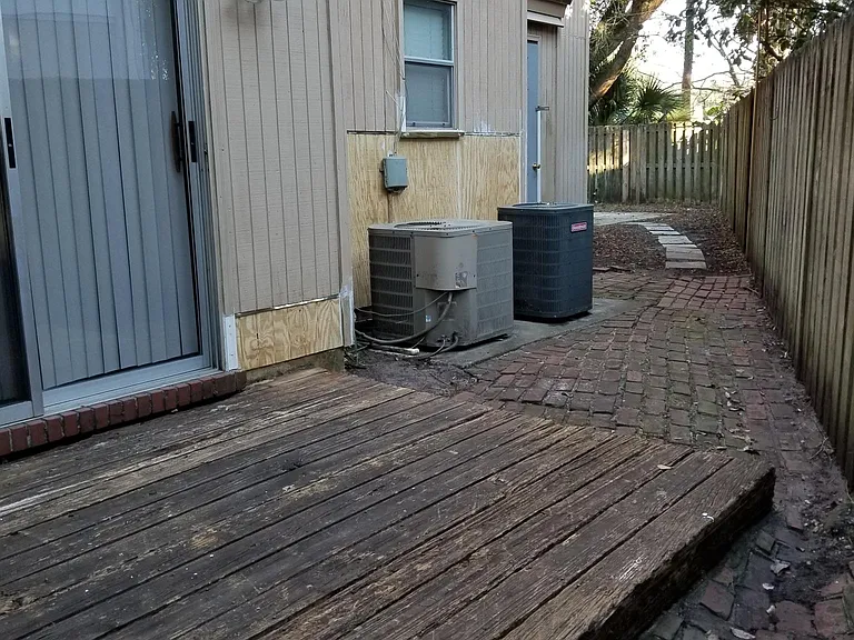 Deck by dining area and walkway to enclosed backyard.