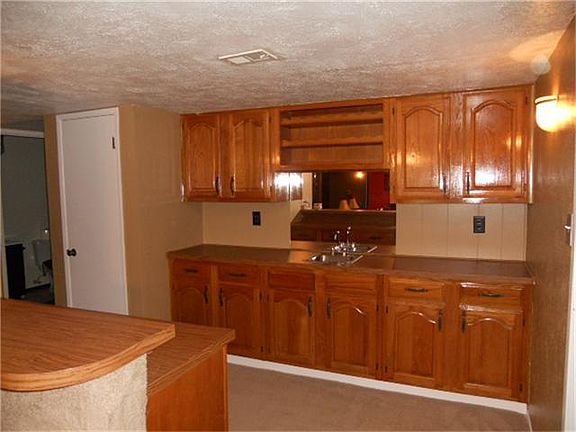 Beautiful wooden wet bar area that looks back out to the formal dining and living rooms.