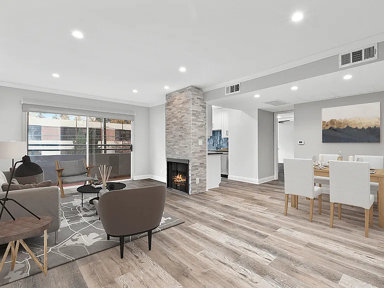 Hardwood floored living room with stone walled fireplace.
