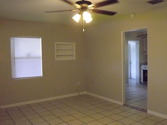 Living Room (left) with built in shelving. Access to kitchen, bonus room and laundry.