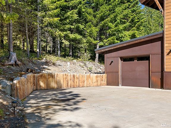 Closer picture of the amazing retaining wall, well thought out and so uniquely beautiful. This garage bay is a drive through, made to easily access your snowmobiles or toys of choice. Check out the metal finish on the bottom. Not only cool looking but practical for keeping snow off your home.