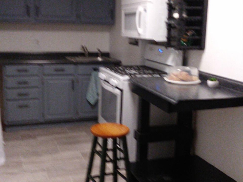 Kitchen with new stove and microwave. Small eating in kitchen 7ft by 17ft