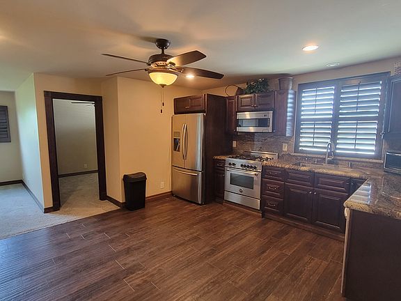view of kitchen area w living room to the left and entry to smaller bedroom/office in the center