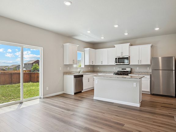 The kitchen has stainless steel appliances and white cabinets.