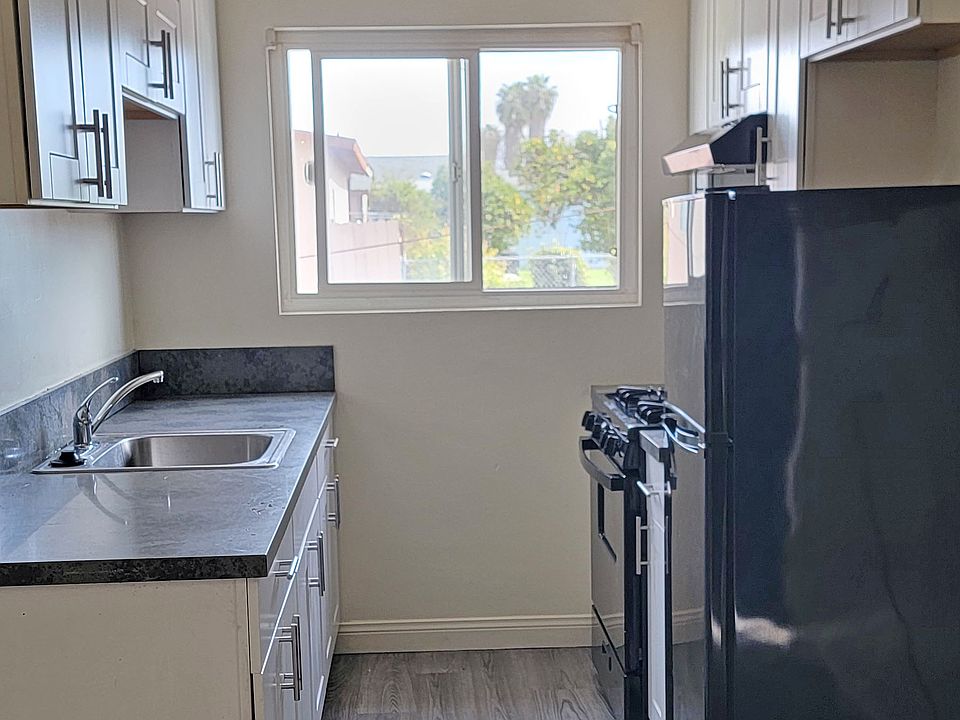 Kitchen with shaker cabinets, refrigerator, and new stove!