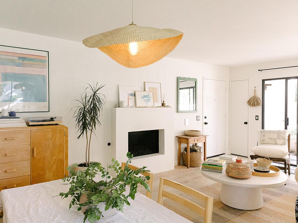 Mixed living and dining space with bright natural light, comfortable furnishings and cozy gas fireplace. New hardwood flooring.