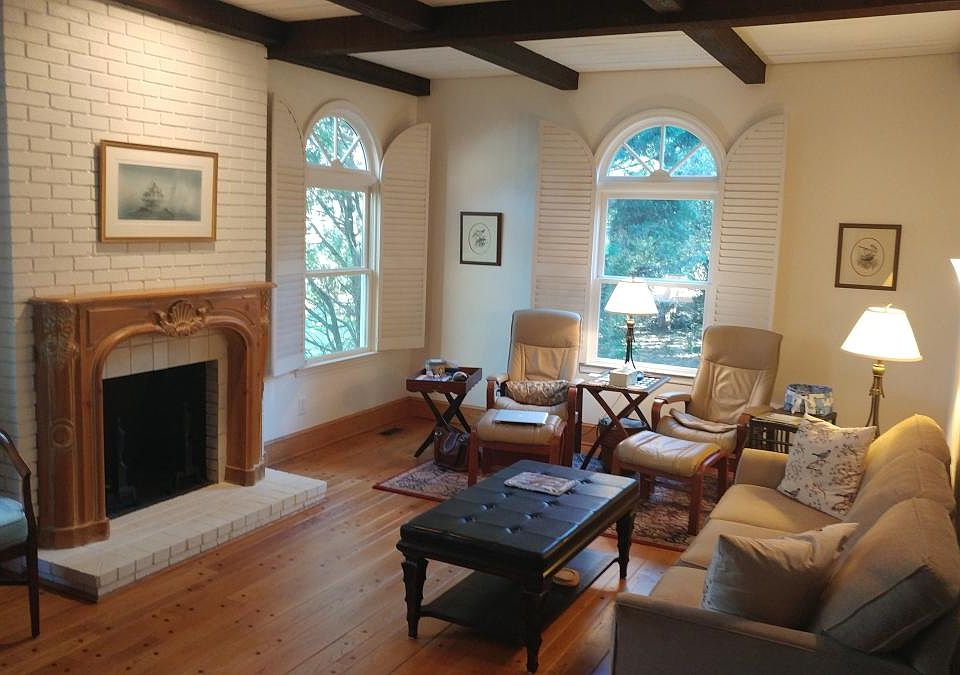 Living room w wood burning fireplace & bay windows