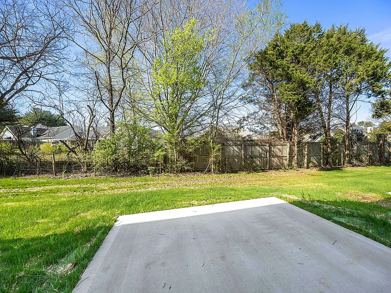 Now let's step outside to see the outdoor living space! Open patio with tree lined yard.