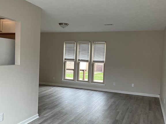 view of dining area into living room from sliding glass door to patio, vinyl flooring