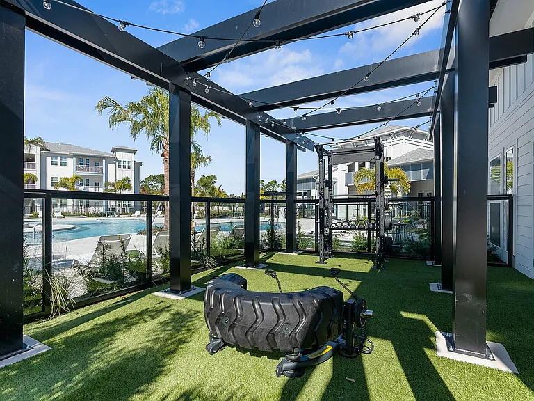 Elevate your workout in this stunning outdoor fitness space with pool views.