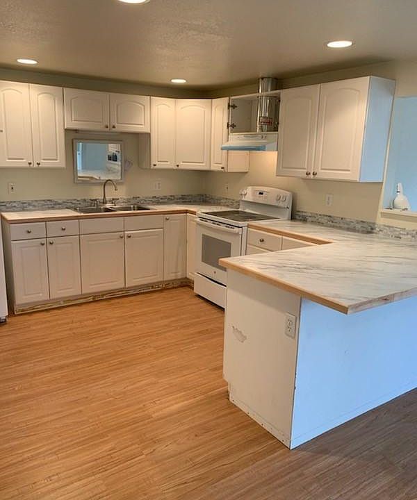 Open kitchen with new counter top and back splash. Bar area and table space for dining.