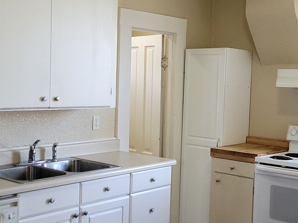Plenty of cabinets that reach to the ceiling. Hardwood floors.