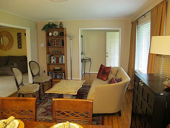 The beautiful living area has the original wood floors, crown molding and large window allowing ligh