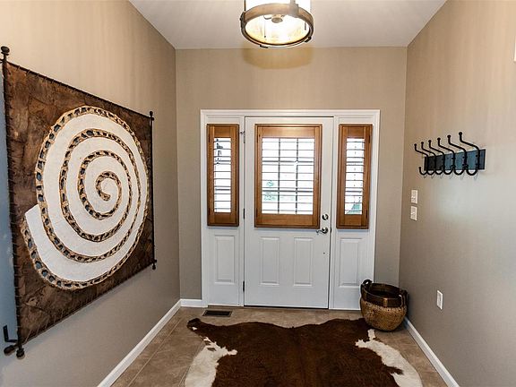 Welcoming entry foyer with updated lighting and plantation shutters.