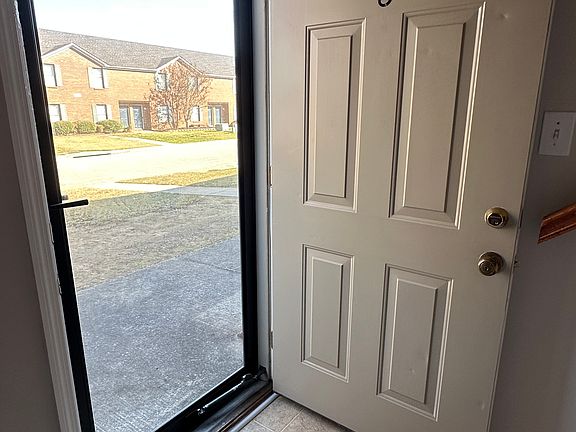The front door of apartment 5 features a new glass storm door with a deadbolt.