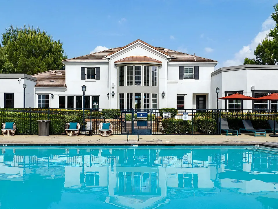 Poolside View Facing Clubhouse with Lounge Chairs and Umbrellas