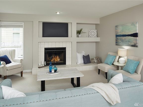 Family room adjacent to kitchen features wood burning fireplace.