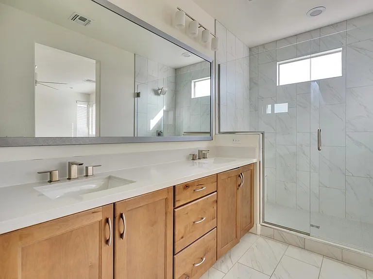 Large en suite master bathroom with dual vanities and oversized shower with rain shower head.