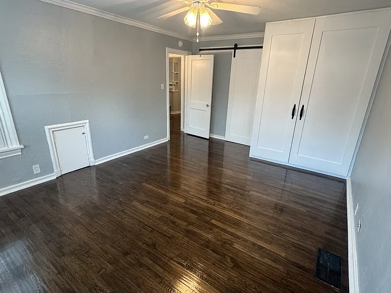 Bedroom with hand scraped hardwood flooring and custom oversized closet and new full size stackable washer and dryer.