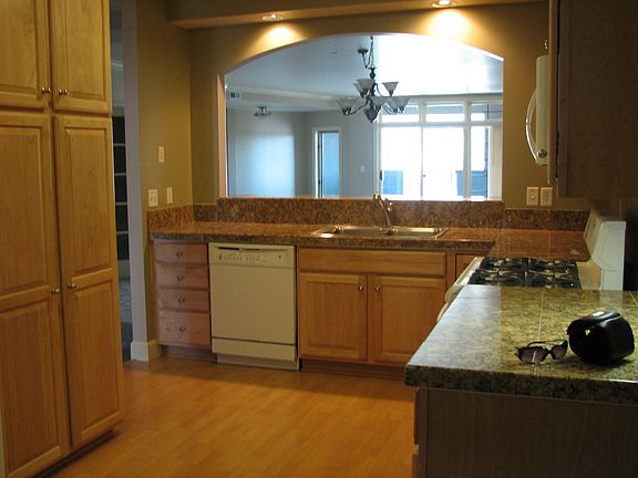 View of the kitchen from the nook.  Granite surfaces.