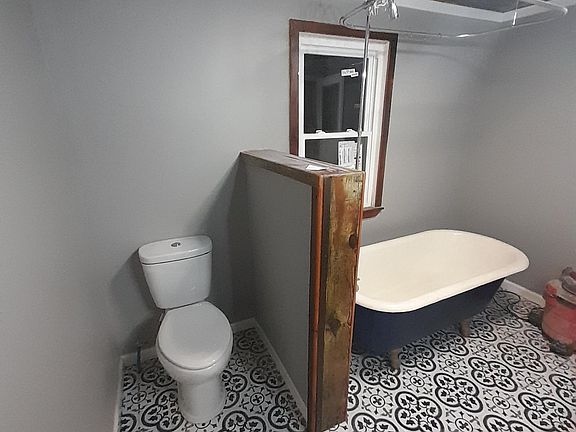 Reclaimed wood trim and original ship lap ceilings and wall divider separating dual flush toilet