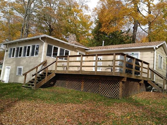Bck of cabin with the sun room and large deck overlooking Bowstring Lake