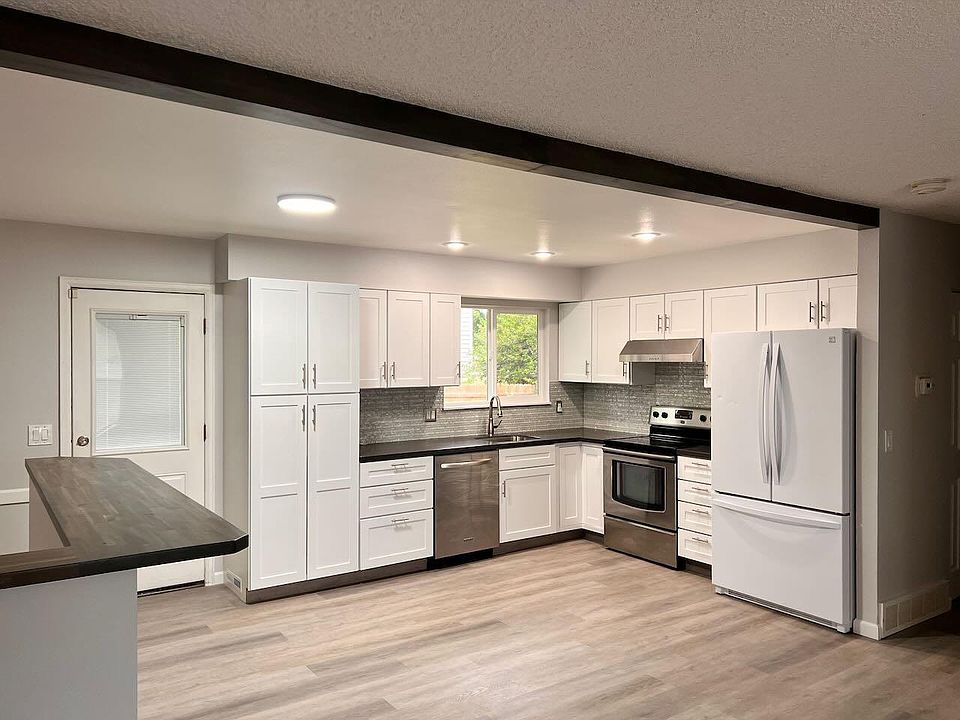 Open concept kitchen area with bar table on left. View from front of house living room.,